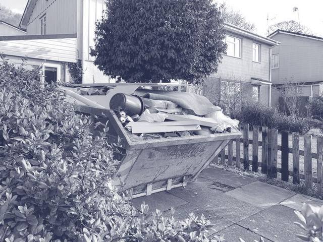 Gefüllter Absetzcontainer steht vor einem Wohnhaus in der Einfahrt
