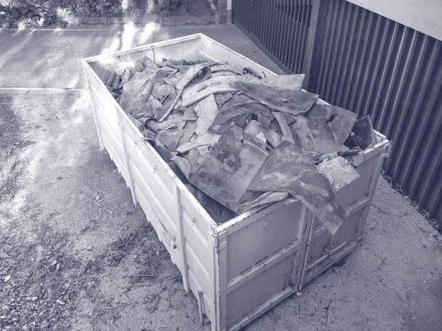 Container mit getrennt gesammelten Bauabfällen auf einem Hof